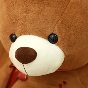 Large brown plush teddy bear detail shot, soft stuffed animal toy with cute red ribbon and heart.