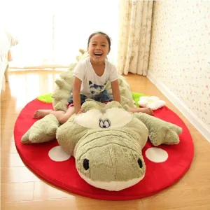 Large crocodile plush toy floor mat with cute strawberry rug for kids room decor and play.