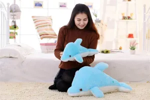 Vista dettagliata di un simpatico cuscino peluche delfino blu luminoso in camera.