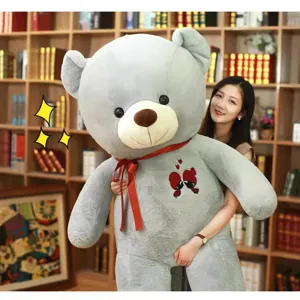 Giant grey teddy bear plush toy with red ribbon and heart embroidery for romantic gifts.