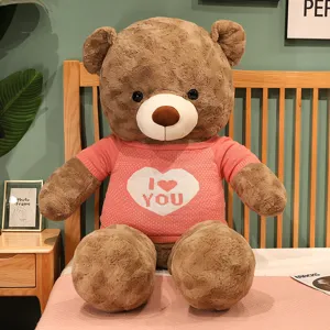 Μεγάλο καφέ αρκουδάκι λούτρινο παιχνίδι με χαριτωμένο ροζ πουλόβερ και σχέδιο καρδιάς.
