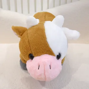 Primo piano dettagliato del peluche mucca marrone e bianca con pelliccia morbida e muso rosa.
