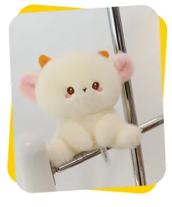 Cute animal plush toy detail showing soft cream fur, pink ears and small horns clearly.