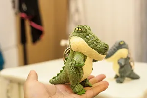 Primer plano del lindo llavero de peluche de cocodrilo simulado, detalle de colgante de bolso.