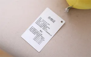 Cute plush toy hangtag detail showing quality compliance and 100 percent polyester filling