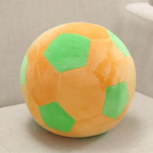 Detailed view of a soft plush soccer ball pillow, featuring orange and green stitched panels.
