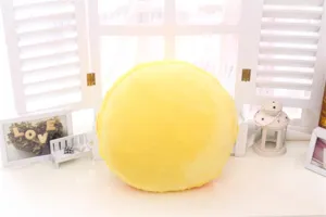 Detailansicht eines weichen runden Macaron Plueschkissens, gemuetliche gelbe Buerodeko.