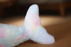 Dettaglio coda delfino di peluche colorato, morbido tessuto arcobaleno per bambini.