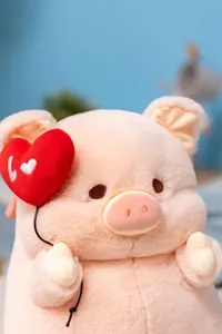Cute pink pig plush toy detail, soft stuffed animal doll with red heart, fluffy gift.