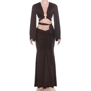 Close-up of brown long sleeve crop top with ring cut-out and ruched maxi skirt detail.