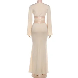 Back view of women solid color sexy hollow long sleeve crop top and slim maxi skirt set.
