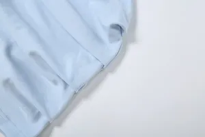 Hellblaue Stoffdetail von Damen Sommerbekleidung, weiche Textur und feine Faltennähte.