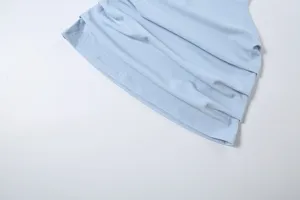 Hellblaue Damenbekleidung Stoff Detailaufnahme, weiche Textur mit feinen Naehten.