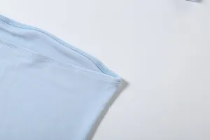 Detailaufnahme der hellblauen trägerlosen Oberteilkante mit feiner Textur und sauberer Naht.