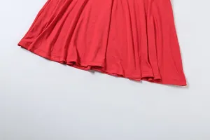 Detailaufnahme des roten Rocksaums mit feinem Stoff und sauberer Naht, schlichtes Design.