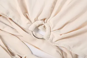 Beige women summer set detail view featuring metal ring, cutout straps and pleated fabric.