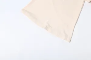 Close-up detail of the solid color flared hem, featuring neat stitching and smooth fabric.