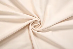 Close up view of soft beige fabric featuring detailed textile texture and elegant swirl pattern.