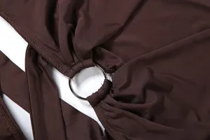Close-up of women's brown cut-out top detail with metal ring and ruching design elements.