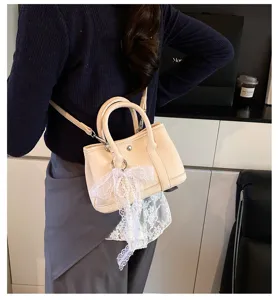 Schicke Damen Umhängetasche aus Leder in Beige, mit süßer Spitzen-Schleife und Tragegriff.