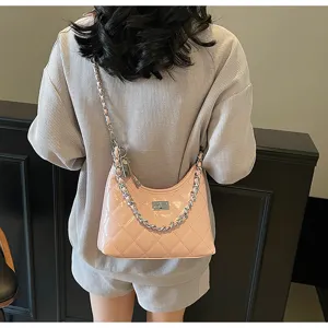 Détail du sac à main matelassé rose avec chaîne, élégant sac bandoulière tendance mode.