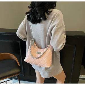 Élégant sac à bandoulière matelassé rose avec bandoulière chaîne en métal et détail de fermoir.