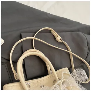 Cremefarbene Damen Handtasche Detailaufnahme, stilvolle Perlen Schleife Umhängetasche.