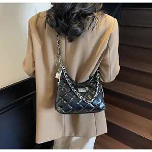 Sac bandoulière femme noir en cuir verni matelassé avec chaîne métal et fermoir tournant.