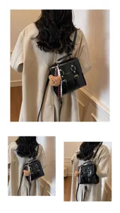 Vista dettagliata del mini zaino nero in pelle con ciondolo a forma di orsetto e fibbie chic.