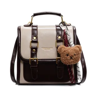 Zaino e borsa a tracolla bicolore chic da donna con ciondolo a forma di orsetto e fibbie.