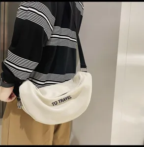 Vista detallada del elegante bolso de hombro blanco con estampado y correa ajustable.