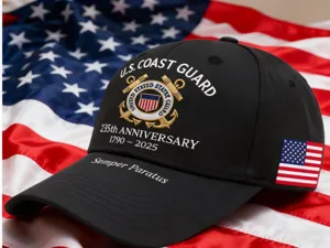 Black baseball cap with U.S. Coast Guard 235th anniversary embroidery and American flag.