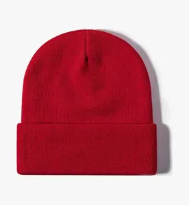 Detailed view of a classic solid red knit beanie featuring a stylish rolled brim and cozy fabric.