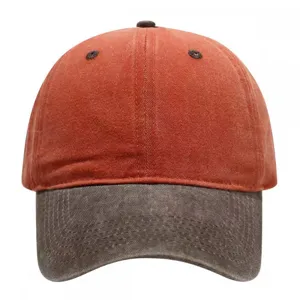 Washed vintage baseball cap with orange crown and contrast dark brim. Detail view of retro hat.