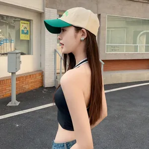Side detail view of stylish two-tone baseball cap with green embroidery and curved brim.
