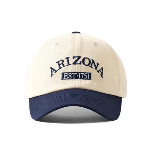 Closeup view of a stylish two-tone baseball cap with embroidered lettering and curved brim.