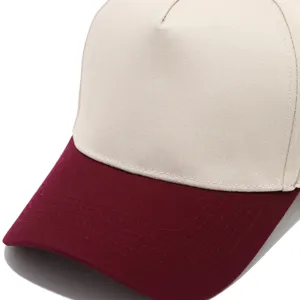 Detailed view of a two-tone trucker baseball cap with beige crown and maroon brim.