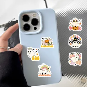 Vista dettagliata di simpatici adesivi con fantasmi di Halloween su una cover per cellulare.