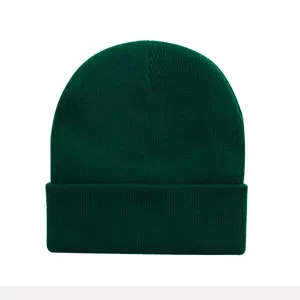 Close-up detail shot of a dark green knitted beanie, showing fine ribbed texture and cozy cuff.