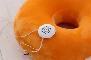 Soft plush donut throw pillow with integrated music speaker detail, cozy office nap cushion.