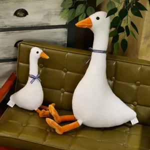 Primo piano di simpatiche oche di peluche dal collo lungo sedute su un divano vintage verde.