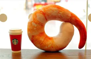 Vista de cerca de un cojín de felpa creativo con forma de langostino, suave y cómodo.