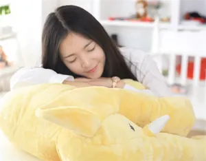 Close-up detail shot of a cozy soft yellow elephant plush pillow featuring a resting model.