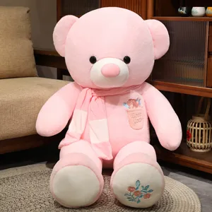 Orsacchiotto di peluche rosa gigante con morbida sciarpa e ricamo floreale per regalo.