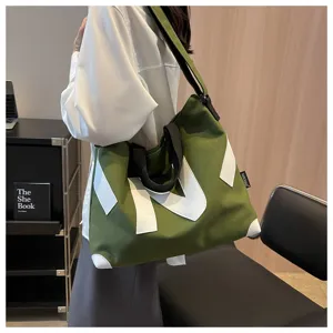 Green canvas tote bag detail, large capacity commuter handbag with shoulder strap and design.