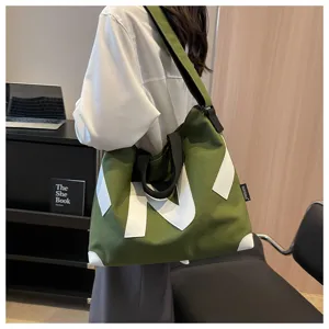 Large green canvas shoulder tote bag detail view, casual style for daily commute and students.