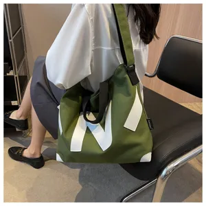 Large capacity green canvas tote bag detail view, stylish shoulder messenger bag for daily use.