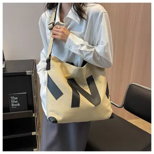 Large capacity canvas tote bag for women commuting, casual shoulder handbag with letter design.