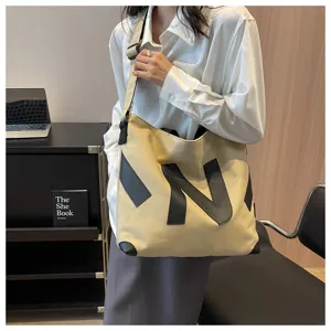 Large canvas tote bag for women, stylish commuting shoulder bag with geometric design.