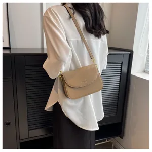 Detail view shot of stylish khaki crossbody shoulder bag with flap design for women.